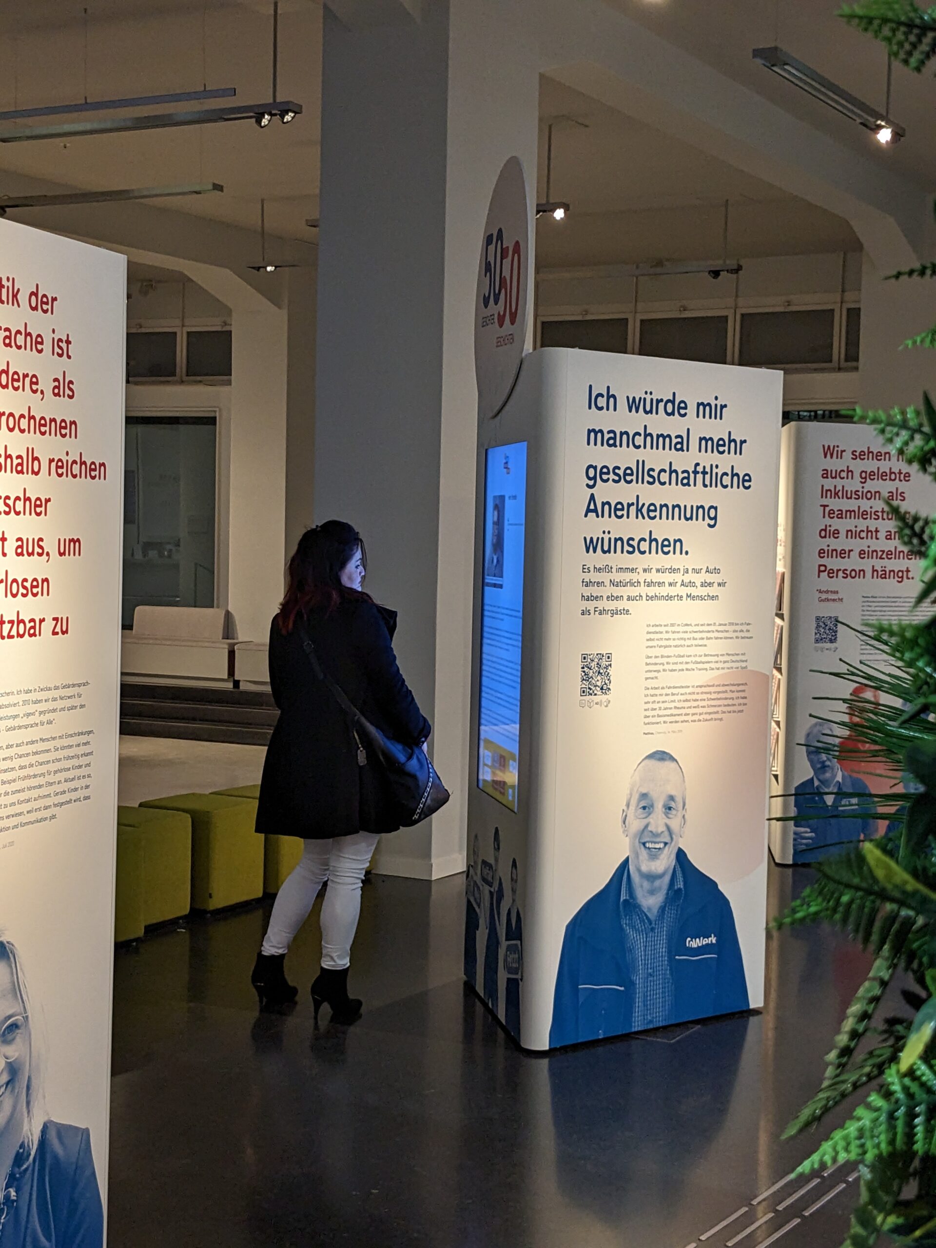 Ausstellung im smac - Eine Frau steht vor der Medienstation und liest sich etwas durch.
